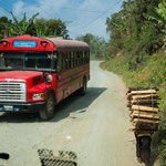 ....links ein Überlandbus und rechts ein Holzptransport per Muskelkraft.....